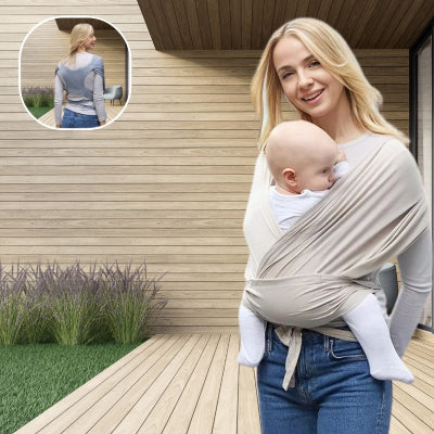 Jeune-maman-devant-sa-maison-prenant-l-air-sur-sa-terrasse-portant-dans-son-écharpe-de-portage-bébé-beige-au-tissu-souple-son-bébé-heureux.