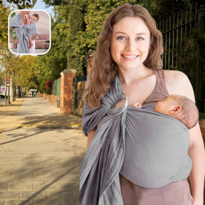 Jeune-maman-marchant-sur-un-trottoir-arboré-portant-son-nouveau-né-en-position-M-dans-son-écharpe-de-portage-grise-facilement installée-souple-élégante-sûre.