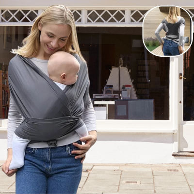 Maman-devant-une-devanture-de-magasin-portant-tout-contre-elle-dans-son-écharpe-de-portage-bébé-anti-baby-blues-gris foncé-au-tissu-souple-son-bébé-attendrissant.