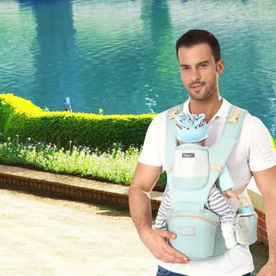 Papa promenade portant bébé dans porte bébé bleu souple poches pratique