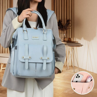 Maman-portant-dans-son-salon-son-sac-à-dos-à-langer-bleu-spacieux-design-ergonomique-comprenant-une-poche-pour-le-téléphone