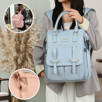 Maman-très-élégante-portant-son-sac-à-dos-à-langer-bleu-par-les-poignées-design-et-s-apprêtant-à-aller-faire-des-courses