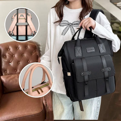 Maman-dans-son-salon-portant-sur-son-épaule-son-sac-à-dos-à-langer-noir-spacieux-élégant-contenant-biberons-couches-lingettes-et-pouvant-se-poser-sur-une-autre-valise-pour-le-transport