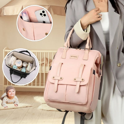 Maman-vêtue-d-un-ensemble-très-habillé-portant-à-son-bras-son-sac-à-dos-à-langer-rose-multipoches-et-design-se-trouvant-dans-la-chambre-de-son-fils