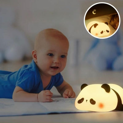 Bébé-à-plat-ventre-sur-un-tapis-dans-son-salon-voulant-attraper-sa-veilleuse-bébé-en-forme-de-panda