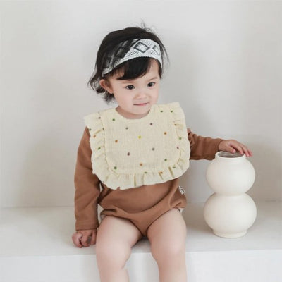 Bébé bavoir bebe fille beige recouvrant salon