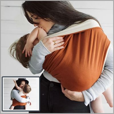 Maman-embrassant-chaleureusement-son-bébé-installé-dans-son-écharpe-de-portage-colorée-souple