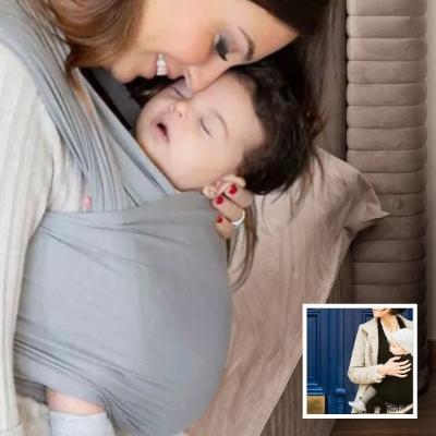 Bébé-endormi-dans-son-écharpe-de-portage-enveloppante-dans-les-bras-de-sa-maman-dans-sa-chambre
