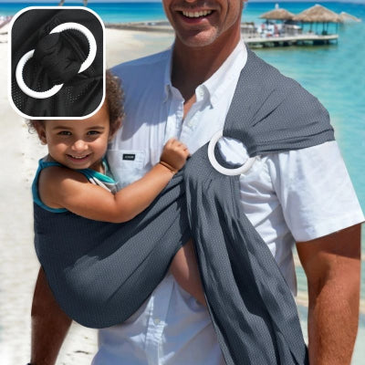 Jeune-papa-à-la-plage-portant-son-bébé-dans-son-écharpe-de-portage-gris foncé-réglable-ajustable-élégante
