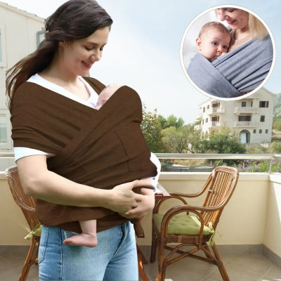 Maman-heureuse-sur-la-terrasse-de-son-appartement-portant-son-bébé-peau-à-peau-dans-son-echarpe-porte-bebe-marron-anti-baby-blues