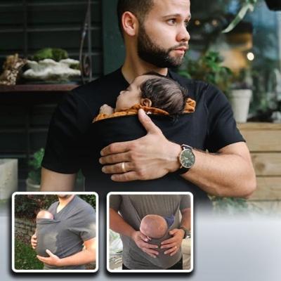 bébé-dans-le-porte-bebe-physiologique-T-shirt-dormant-dans-les-bras-de-son papa-dans-une-cour-interieure