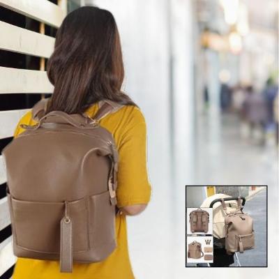 Jeune-maman-portant-un-tee-shirt-jaune-portant-sur-son-dos-son-sac-à-langer-de-couleur-caramel-transformé-en-sac-à-main-dorsal-se-promenant-dans-une-galerie-marchande-d-un-centre-commercial