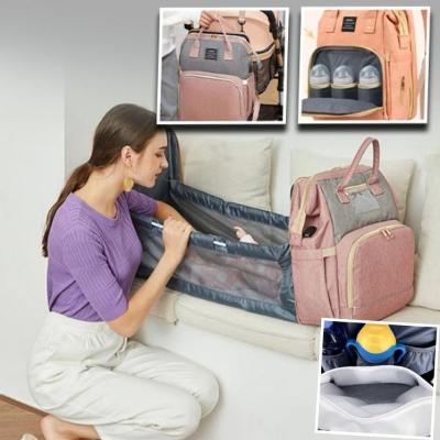 maman-est-assise-accroupie-dans-son-salon-à-côté-de-son-canapé-beige-sur-lequel-elle-a-installé-son-sac-à-langer-rose-transformé-en-lit-dans-lequel-bébé-s-est-endormi