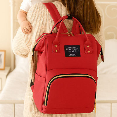 Bebe bras maman portant dos sac a langer de luxe design rouge fonctionnelle