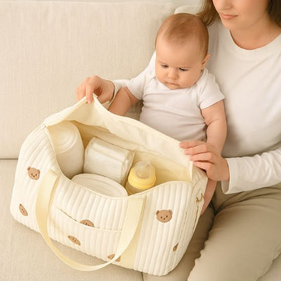 Bébé assis genoux maman devant sac bebe à langer design élégant beige agencement intérieur volumineux