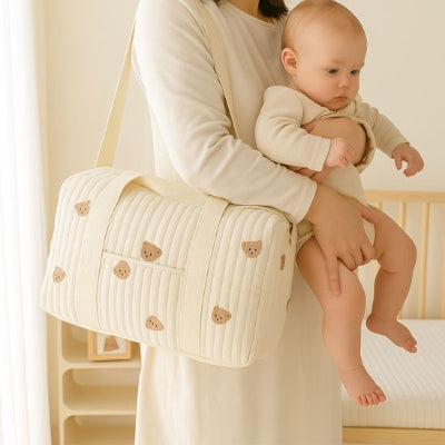 Bébé bras maman portant sac bebe à langer design élégant beige tissu coton chambre