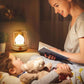Maman-racontant-une-histoire-à-son-bébé-dans-son-lit-éclairé-par-la-lumière-de-sa-veilleuse-bébé-style-rétro-à-minuterie.