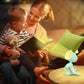 Maman-lisant-une-histoire-à-son-jeune-enfant-éclairé-par-sa-veilleuse-bébé-cerf-bleu-multipositions