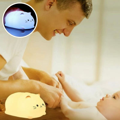 Papa changeant son bébé éclairé par veilleuse bébé chat jaune et blanc.