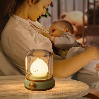 Maman-dans-son-salon-donnant-le-sein-à-son-bébé-éclairé-par-sa-veilleuse-bébé-verte-style-rétro-à-lumière-douce.