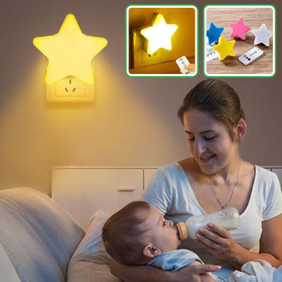 Maman-donnant-le-biberon-à-son-bébé-assise-sur-un-canapé-éclairée-par-sa-veilleuse-murale-bébé-jaune-douce-en-forme-d-étoile