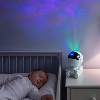 Bébé dort chambre bercé par veilleuse projection bebe design astronaute ludique